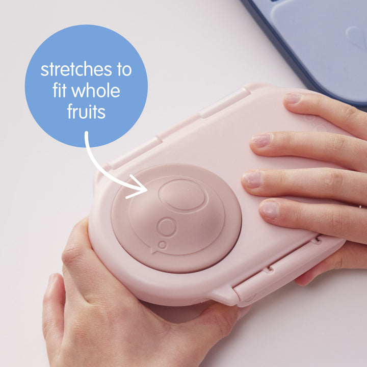 Our pink snack container with a circular red seal on the lid, designed for holding snacks with a whole fruit holder.