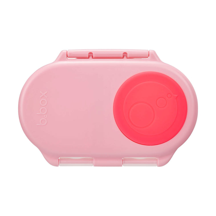 Our pink snack container with a circular red seal on the lid, designed for holding snacks with a whole fruit holder.