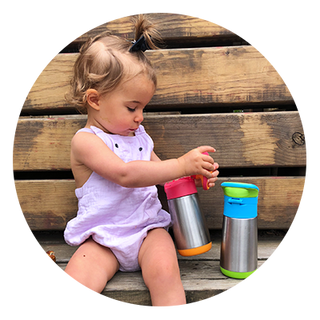 little girl sitting on bench with insulated drink bottle